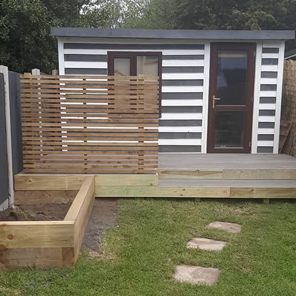 black and white striped garden play shed on decking