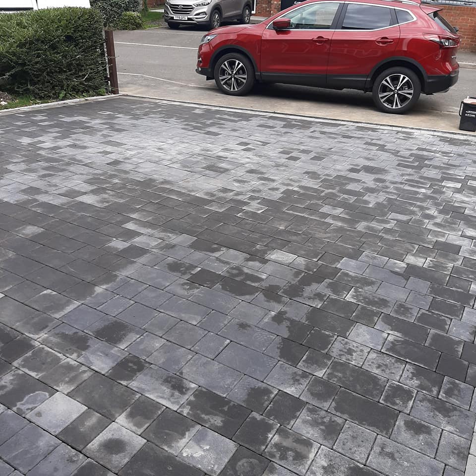 new block driveway with border finished with red car