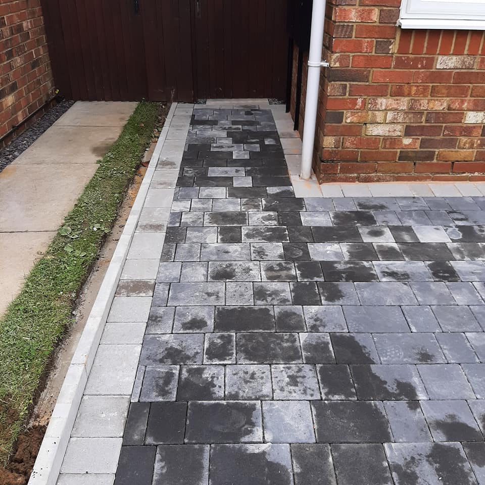 detail of block laid driveway at side of house with drain