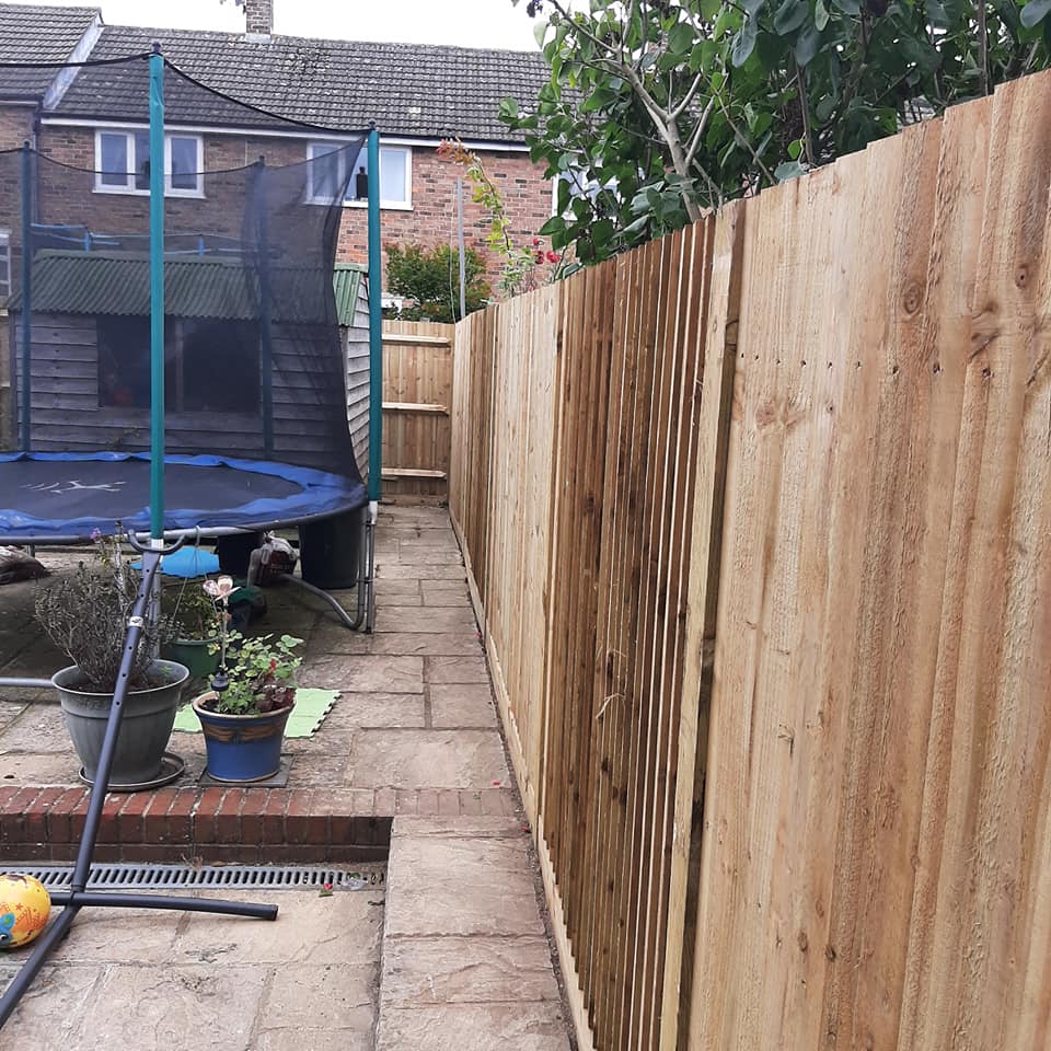 new garden fence around patio with trampoline