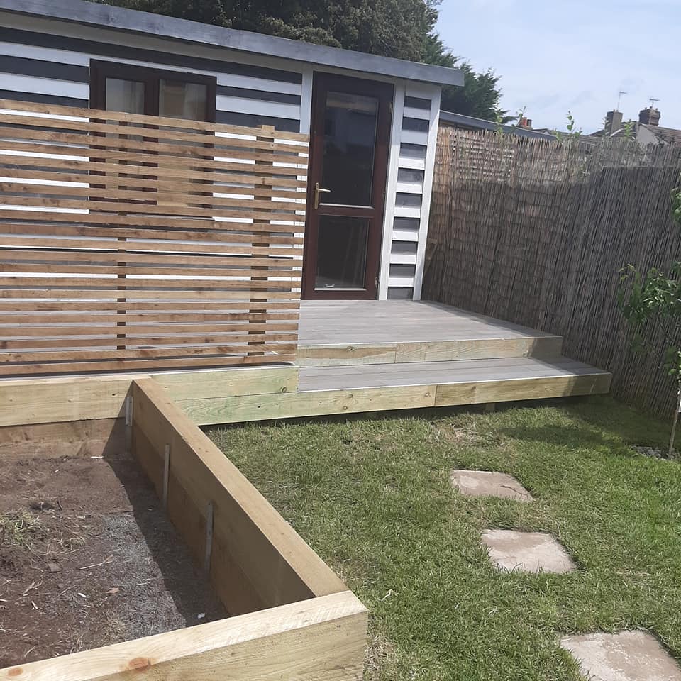 black and white play shed on new decking with fence